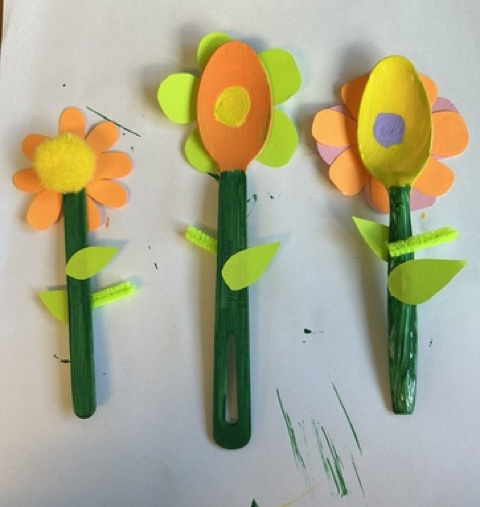 Three handmade spoon-and-popsicle-stick flower crafts